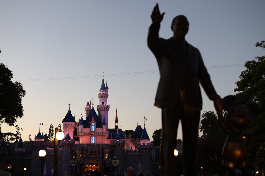 Photo of disneyland castle with the walt and mickey partners statue blurred in the foreground